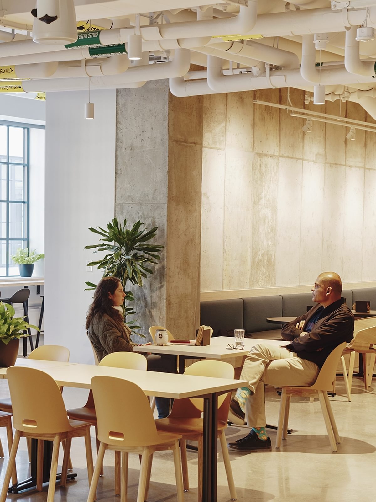 Two Tough Tech residents have a conversation in the common space on the fourth floor of The Engine.