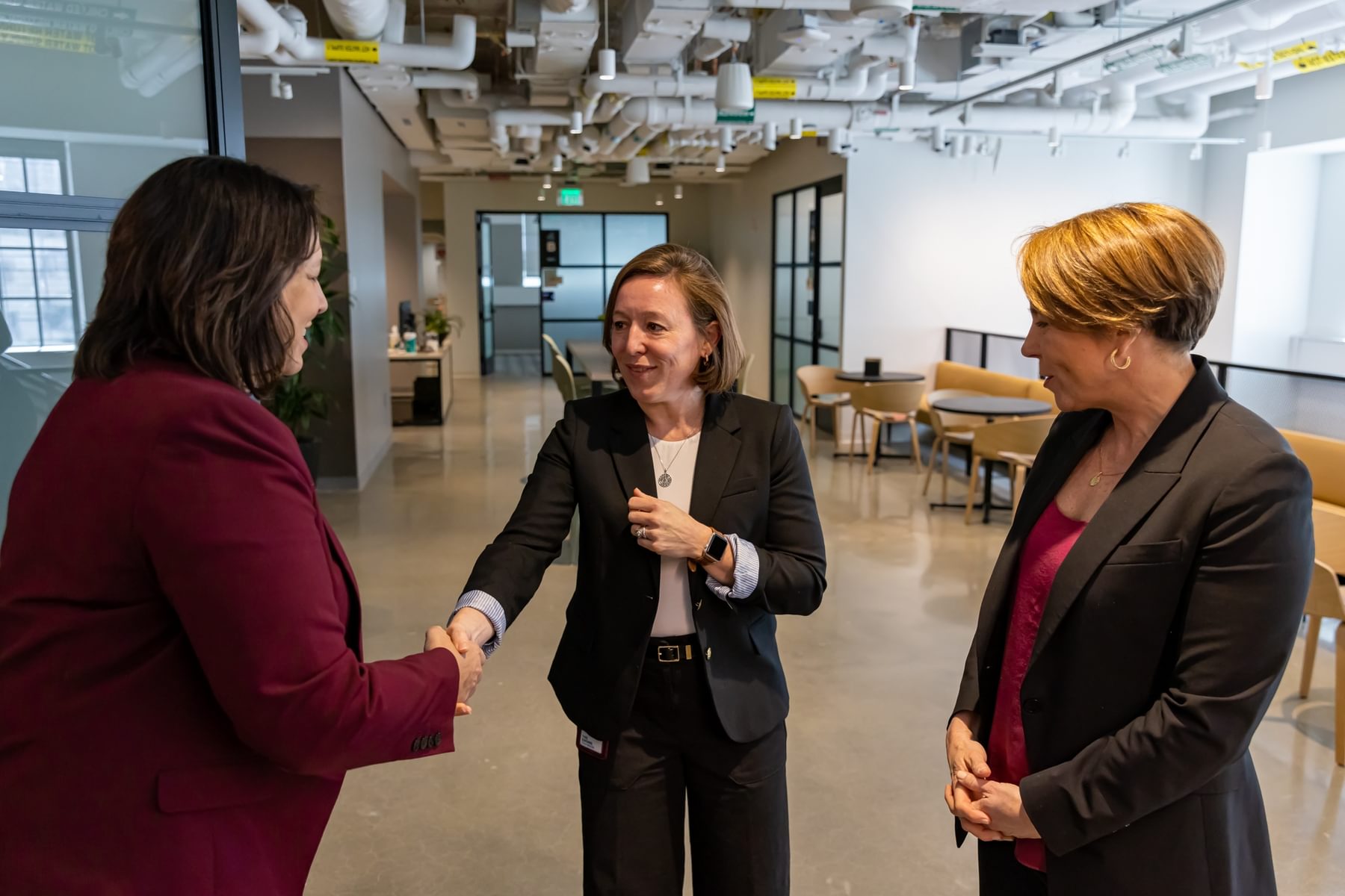 The Engine CEO Emily Knight shakes hands with two women at The Engine.