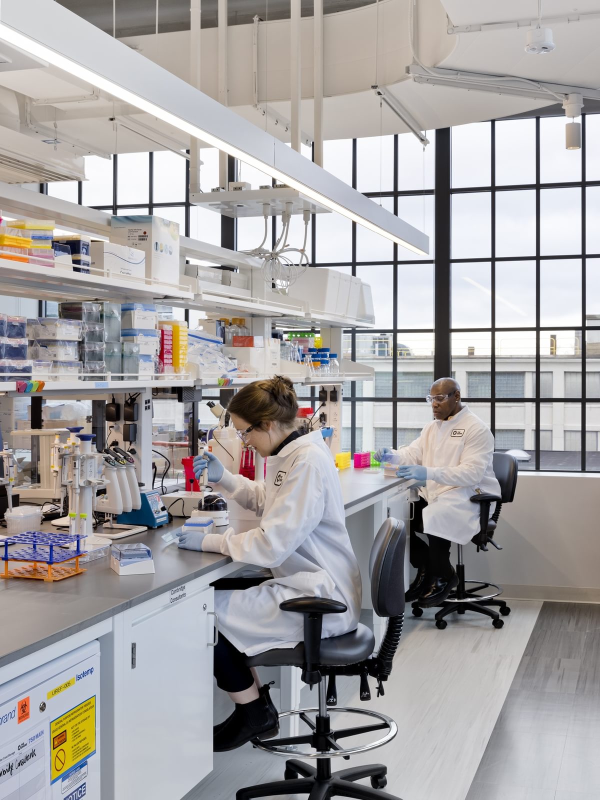 A resident scientist pipettes in The Engine's BSL-2 wet lab space.