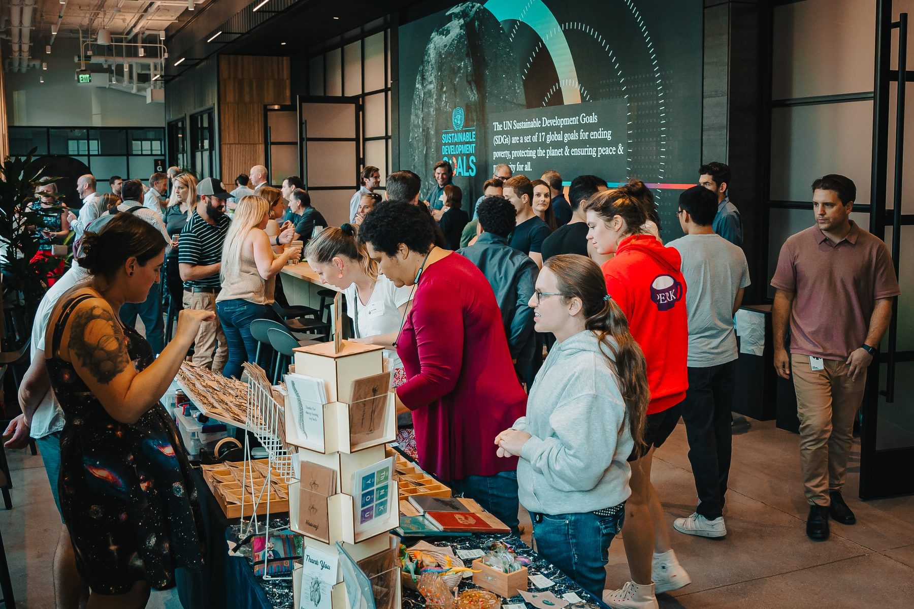 Attendees congregate at a vendor booth during the Spring 2024 Tough Tech Resource Expo in The Engine's event space