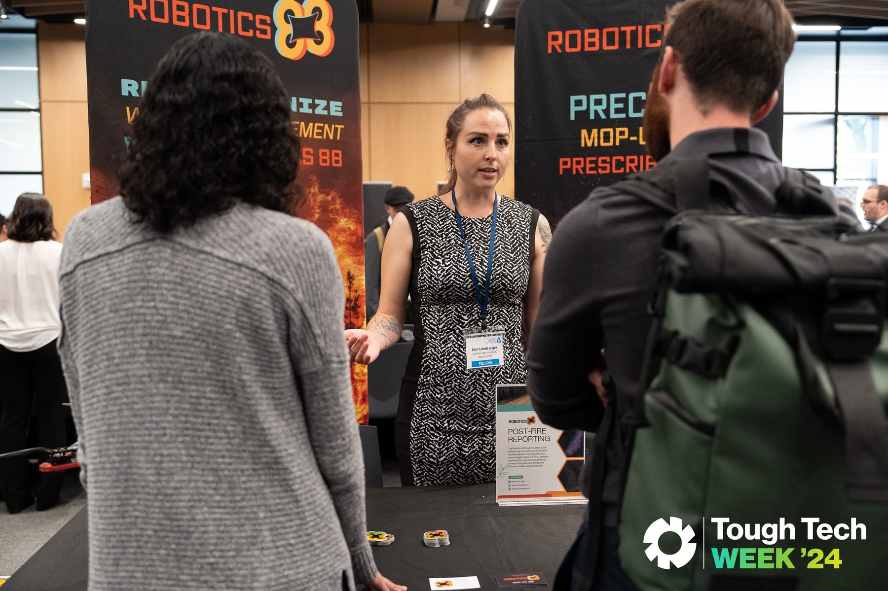 A vendor speaks to two attendees at The Engine's 2024 Tough Tech Week.