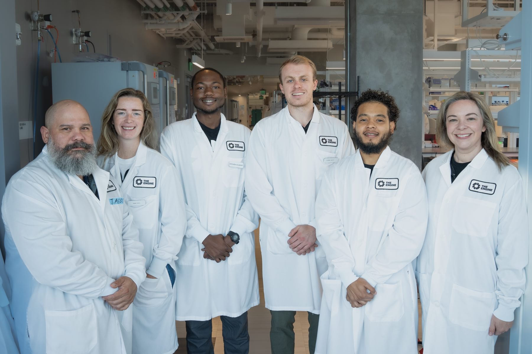 The lab services team at The Engine poses for a photo in lab coats.