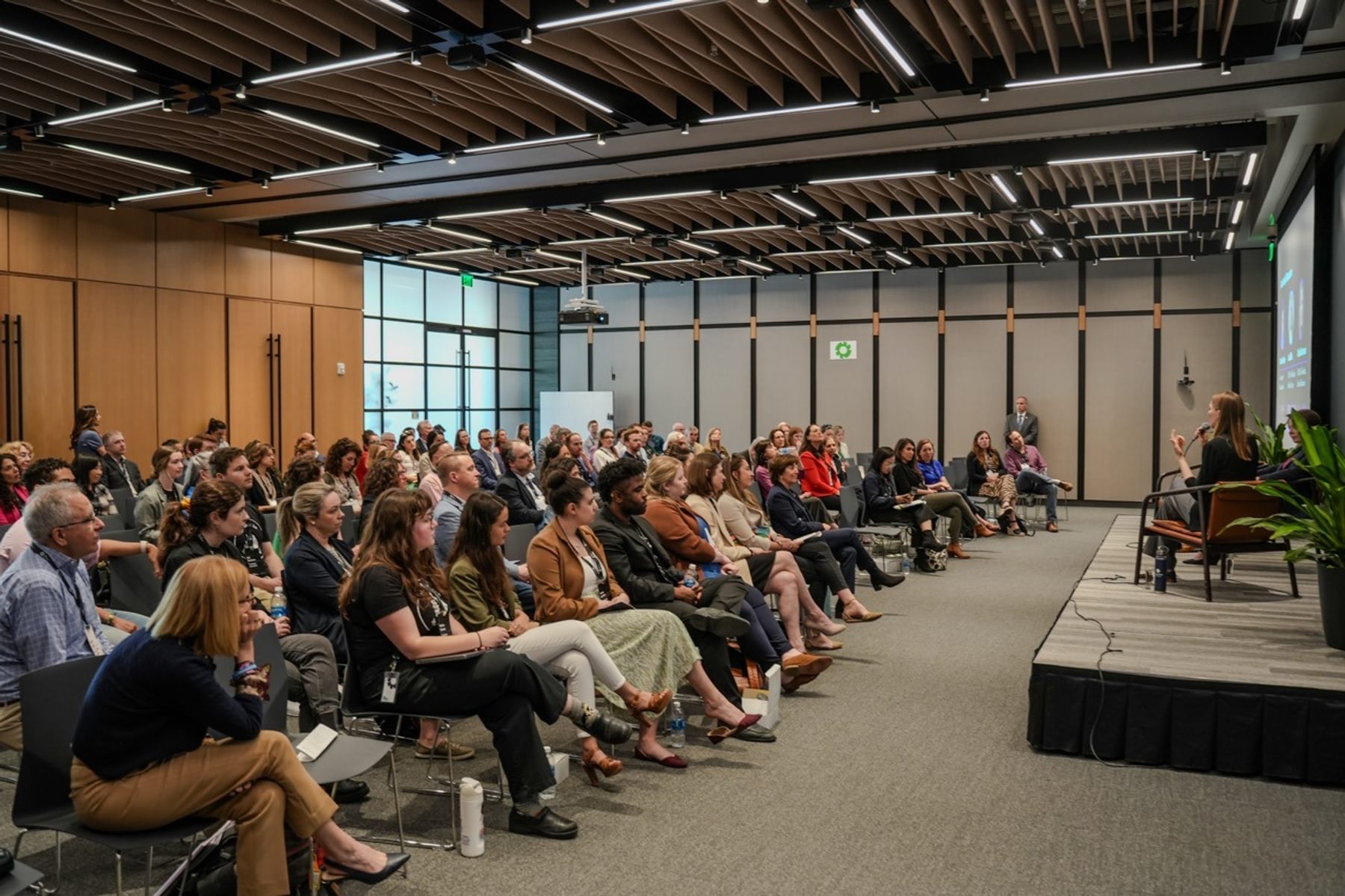 A large crowd sits and listens to a fireside chat in The Engine's event space.