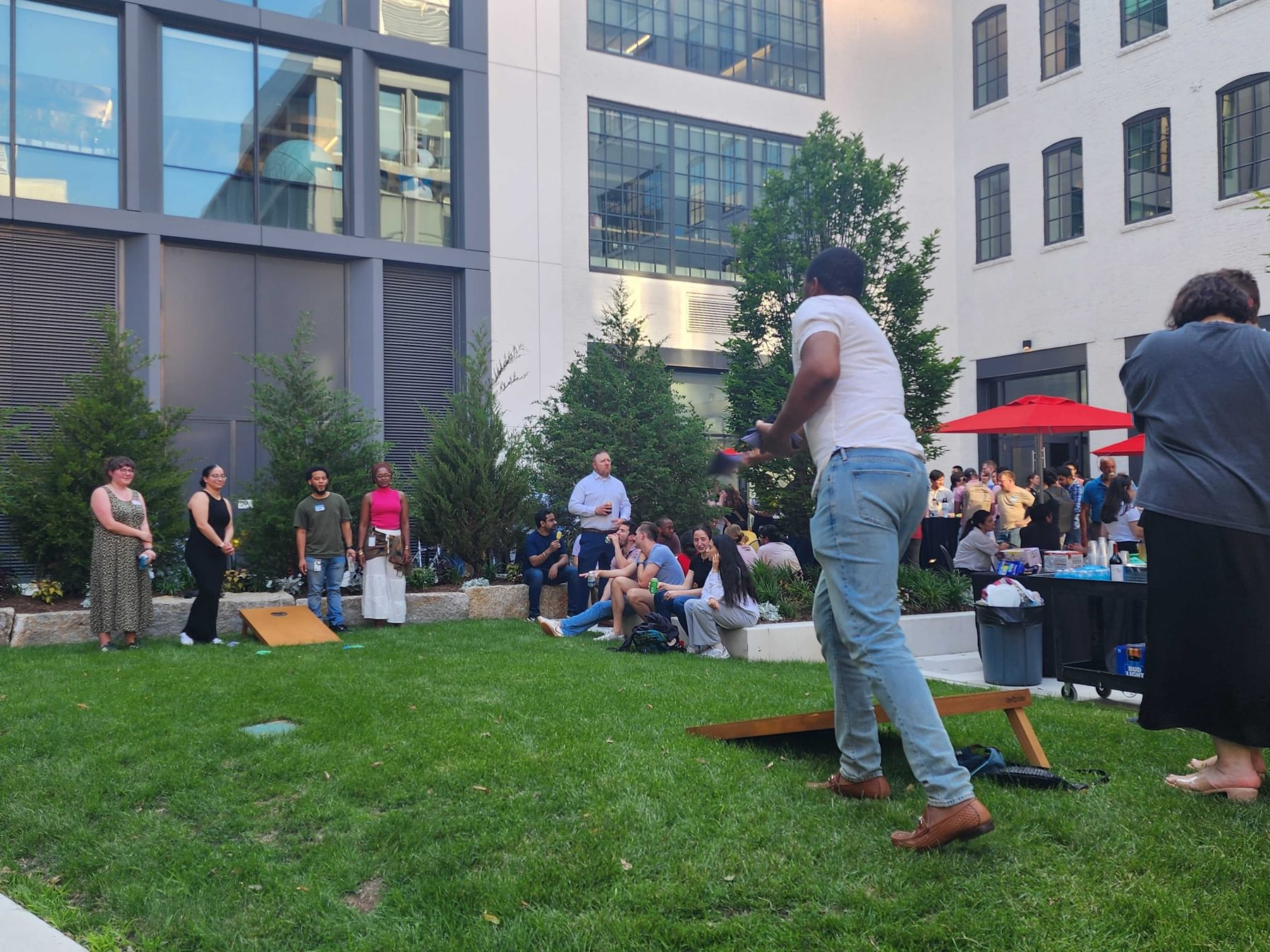 Residents play a game of cornhole in the courtyard at The Engine on a summer evening.